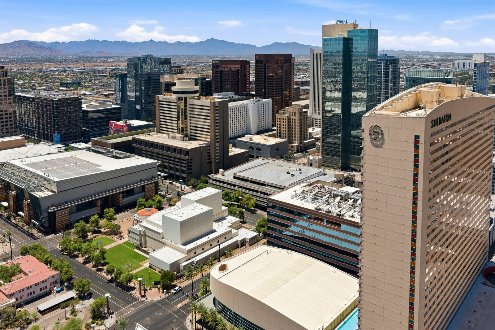 Downtown Phoenix from above: office towers, the convention center and the low warehouse district, with mountains along the skyline
